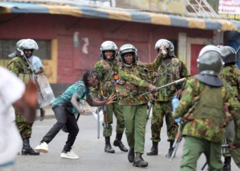 FILE - Police clash with a man during a protest by supporters of Kenya's opposition leader Raila Odinga over the high cost of living and alleged stolen presidential vote, in Nairobi, on March 20, 2023. The United States is praising Kenya's interest in leading a multinational force in Haiti. But weeks ago, the U.S. openly warned Kenyan police officers against violent abuses. Now 1,000 of those police officers might head to Haiti to take on gang warfare. (AP Photo/Brian Inganga, File)